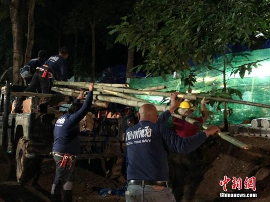 7月5日傍晚，在救援营地，救援人员卸下运来的竹子，准备制作竹筏用于援救被困人员出洞。当天，泰国清莱13名被困洞穴少年足球队成员的救援工作正在持续紧张进行。 /p中新社记者 王国安 摄